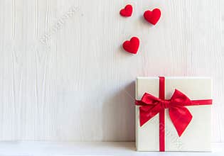 Valentines day white gift box with a red bow on white wall background,