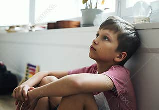 Young boy sitting with depression