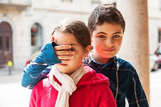 Boy covers eyes of his sister, portrait
