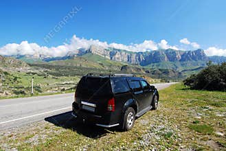Black car on road to mountains