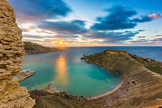 Mgarr, Malta - Panorama of Gnejna bay, the most beautiful beach in Malta at sunset with beautiful colorful sky