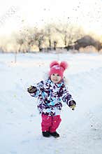 Happy little girl jumps in confetti shower