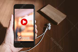 Hand holding mobile watching viral video advertising on phone sc