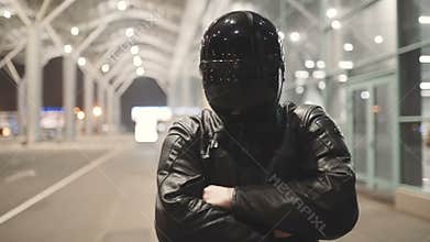 Young attractive man motorcyclist with his helmet and custom motorcycle on night street