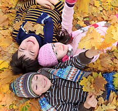 Children lying in fall leaves