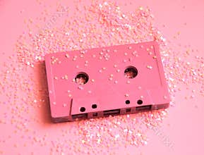 Pink audio cassette tape in glitters. Party concept minimal photo in 90s style