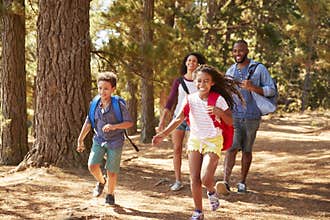 Children Running Ahead Of Parents On Family Hiking Adventure