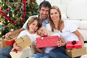 Happy family holding Christmas gifts