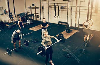 Fit people exercising together with weights in a gym class