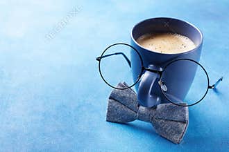 Creative breakfast on Happy Fathers Day with funny face from cup of coffee, eyeglasses and bowtie.