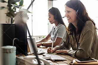 Customer service workers sitting in front of computers working