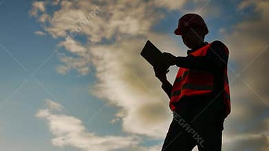 Worker silhouette worker builder man with red helmet and jeans shirt near a industrial wall. silhouette lifestyle worker