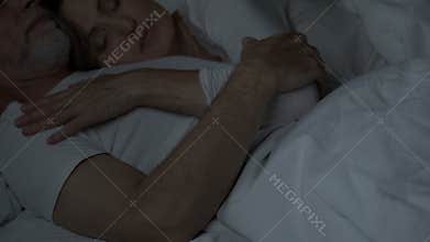 Aged couple sleeping in bed, woman lying on man chest, tender relationship, love