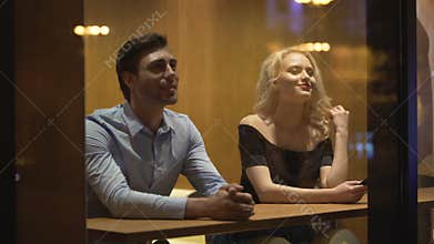 Pretty female flirting with young man at cafe, evening time, pick-up and date
