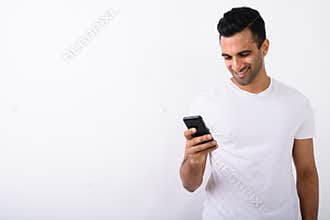 Young handsome Indian man using mobile phone against white backg