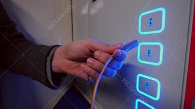 Male hand plug and unplug USB cable to the free charging port