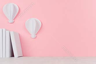 Creative back to school background - white books and hot air balloons origami on soft pink backdrop.