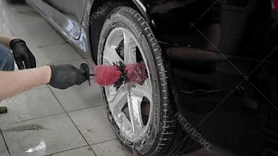 Close up shot of a man washing car disks in carwash.