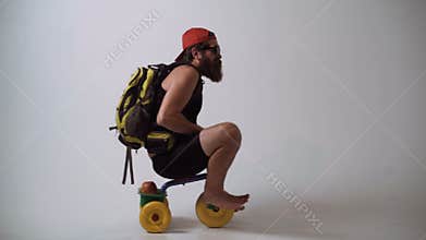 Delivery service. Not baby delivery. A funny bearded man is riding a children`s bicycle