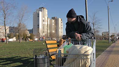Mature homeless man collecting plastic from trash