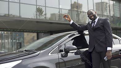 African-American man pleased that fulfilled his dream and bought luxury car