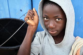 A boy carries a water bucket in a slum in Accra, Ghana