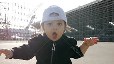 Small child son in a cap running