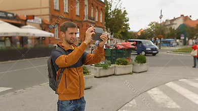 Man tourist filming city attractions on his smartphone, tourism, technologies