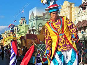 Tired after a day`s work. The ray of setting sun isn`t making the job easy. Man on stilts at an afternoon parade.