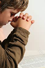 Young boy praying - vertical