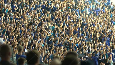 Male supporters clapping hands, cheering for national football team at stadium