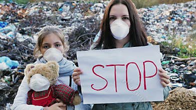 Family activists with Stop poster on waste dump