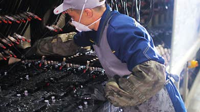 Worker in respirator connects wires to accumulators for test
