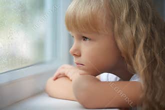 A girl looking out of the window on a rainy day