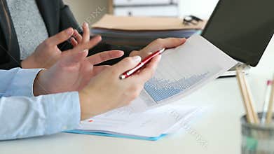 Two office workers analyzing growth graph