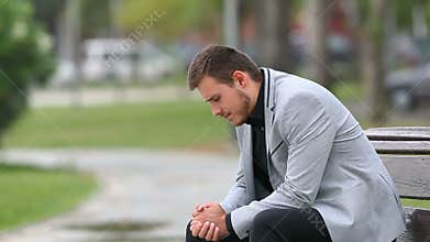 Worried businessman sitting on a bench