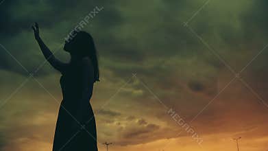 Young woman raising hand up to night scary sky, nightmare, horror mystery