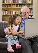 Grandparents and granddaughter with computer