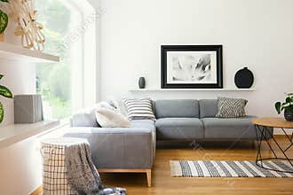Black and white textiles and decorations in a classic scandinavian style living room interior with wooden furniture and natural su