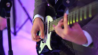 4k guitarist plays acoustic guitar on night club stage, flashes of colour lights