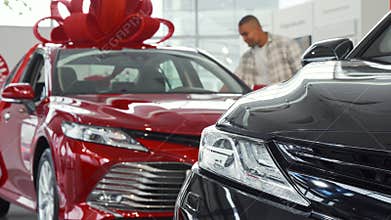 Young African man choosing a new car to buy