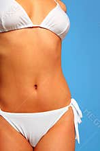 Woman in white bikini with golden sun tan