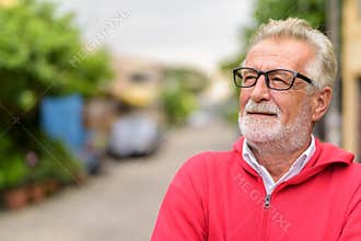 Close up of happy handsome senior bearded man smiling while thin