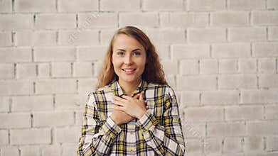 Portrait of happy and excited young woman smiling, laughing and touching face expressing excitement and happiness. Good