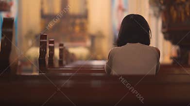 Religious Christian woman praying in church
