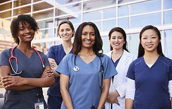 Female healthcare colleagues standing outside hospital