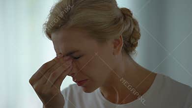 Woman suffering terrible migraine, removing eyeglasses, hypertension, stress