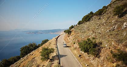 Aerial shot of a car following the beautiful coastline of Kefalonia island, Greece