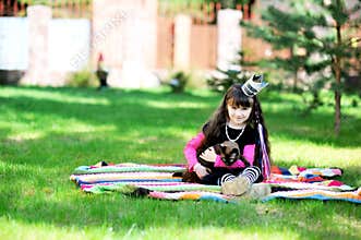 Little princess playing with burma cat outdoors