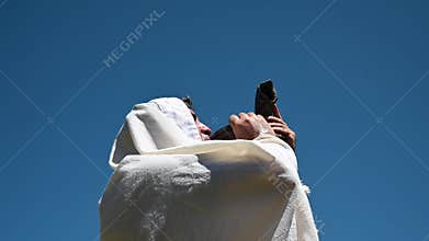 Jewish man blowing Shofar on Rosh Hashana Jewsih Holiday